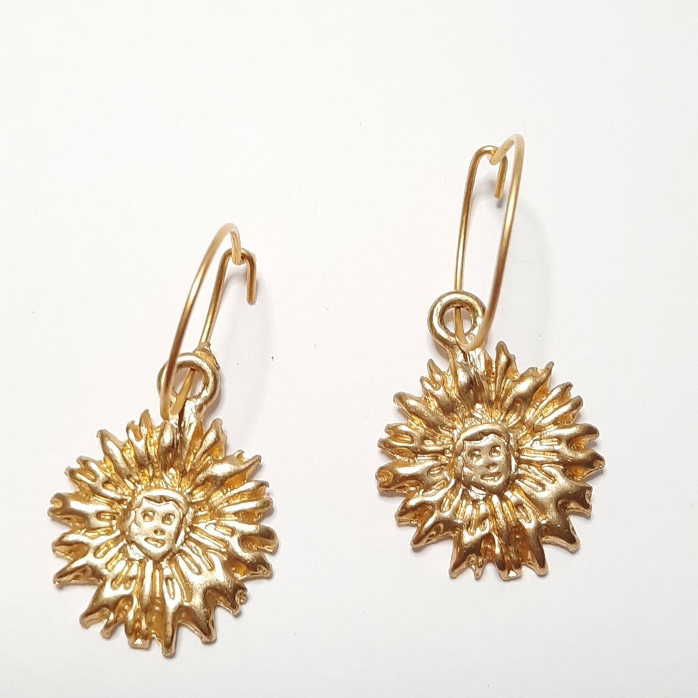 Gold toned earrings with sunbeam and face